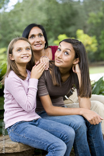 Affectionate mother and two daughters sitting together