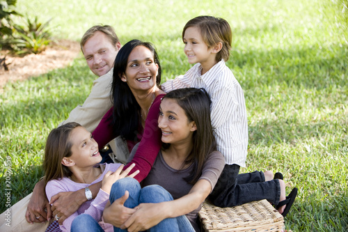 Happy interracial family of five enjoying a picnic in the park