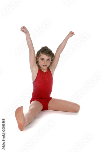 girl in red leotard doing split on high key background