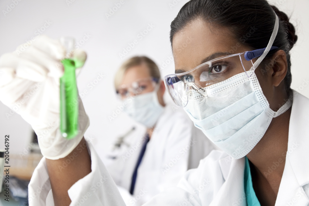 Asian Female Scientist With Laboratory Test Tube of Green Soluti Asian Female Scientist With Laboratory Test Tube of Green Soluti