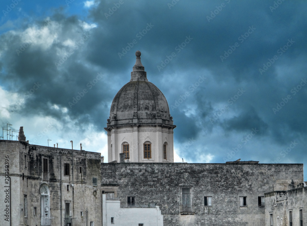 Historic dome standing out in the cloudy sky. Monopoli. Apulia.