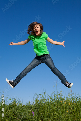 Girl jumping, running against blue sky