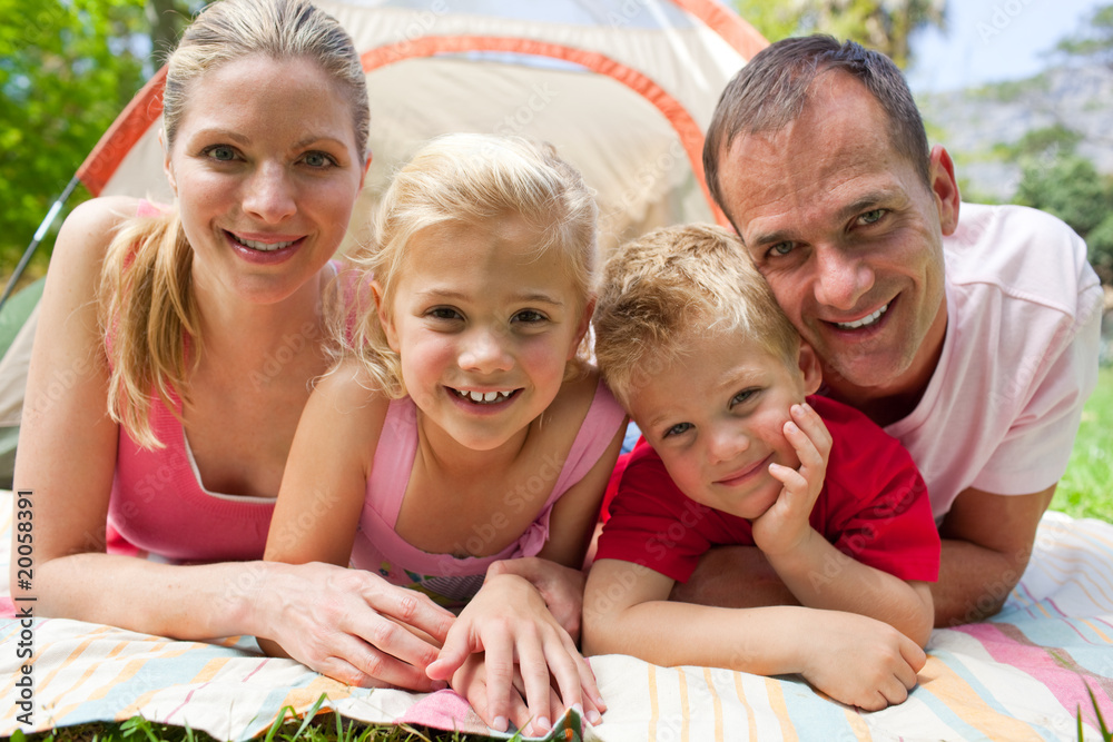 Portrait of a happy family lying on the grass Portrait of a happy family lying on the grass