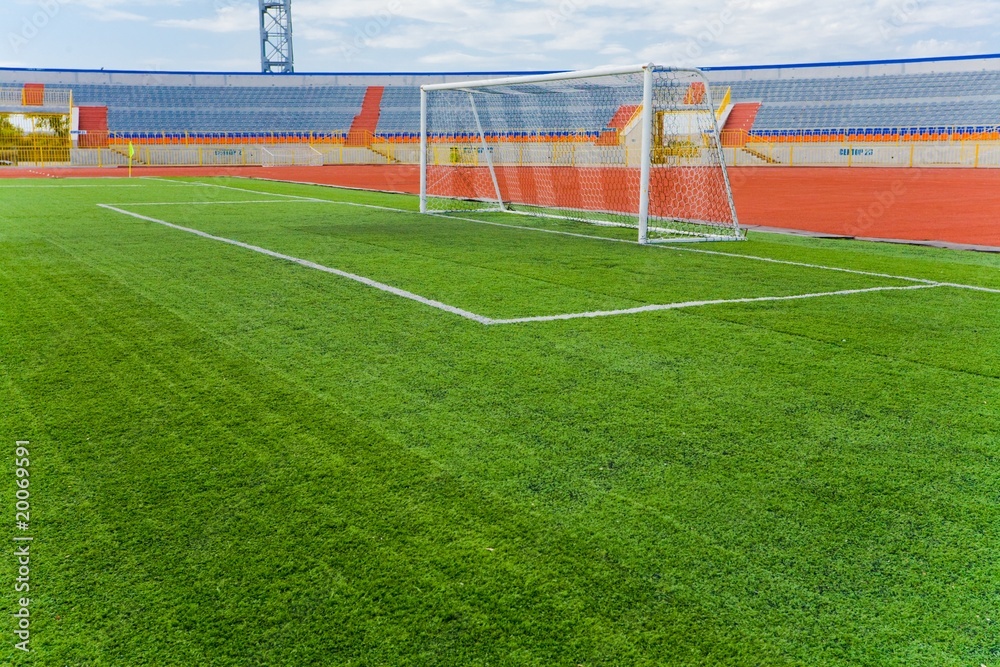 Fototapeta premium STADIUM - Football field with goal and tablo on blue sky