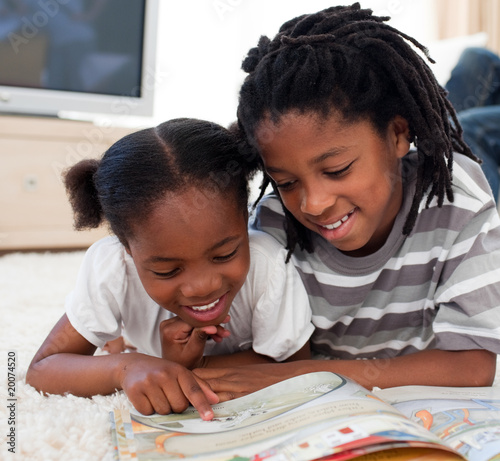 Canvas Print Concentrated siblings reading a book