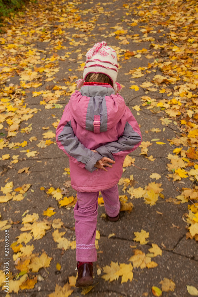 Small girl walk on foot on autumnal park alone Small girl walk on foot on autumnal park alone