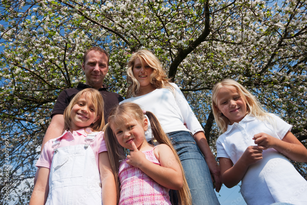 Family under apple tree in spring