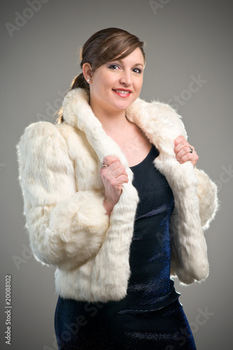 Fashion image featuring woman modeling a white fur jacket