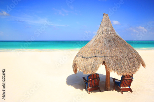 Grass hut and chairs on a gorgeous beach resort