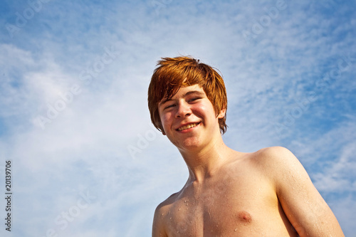 happy boy with red hair is enjoying the beautiful beach
