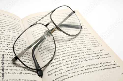 closeup of opened book and glasses.