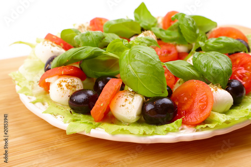Fresh salad with basil, mozzarella, olives and tomato
