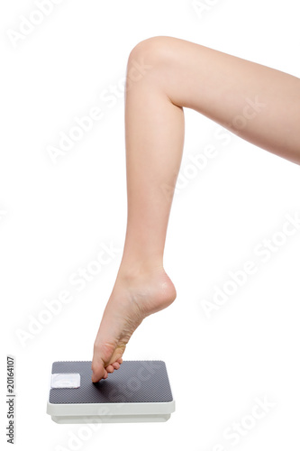 womans leg standing with the toe on a scale