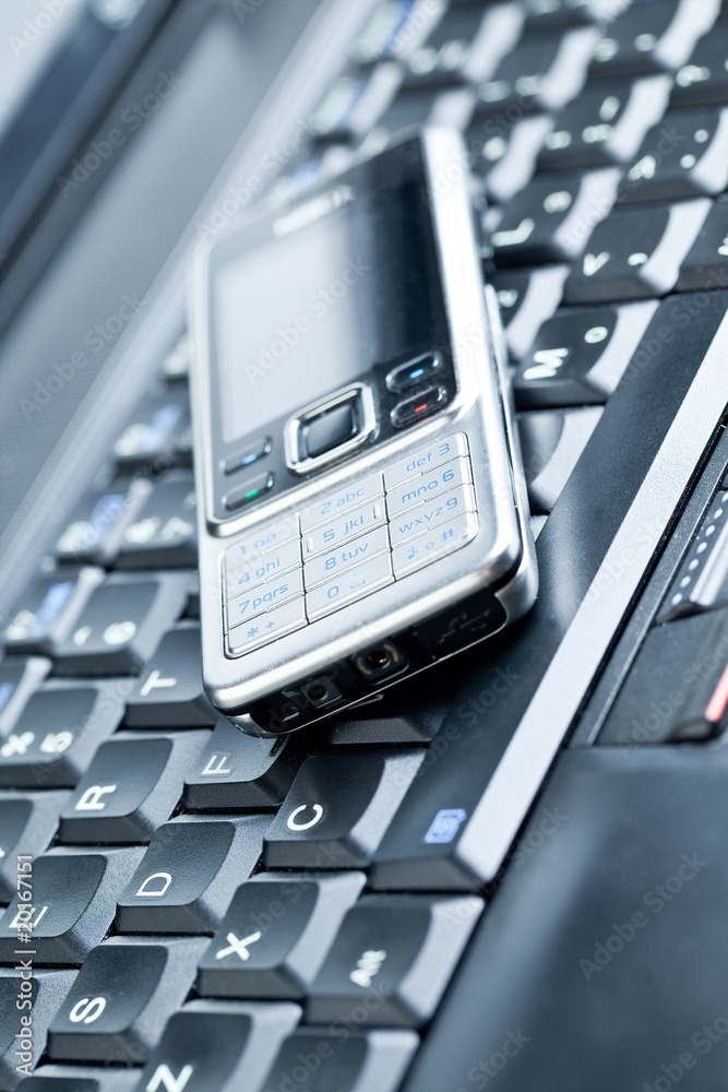 Business concept - mobile phone over laptop keyboard