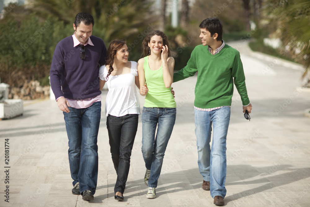 Four happy people walking