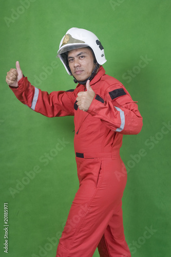 man firefighter with thumbs up isolated on green