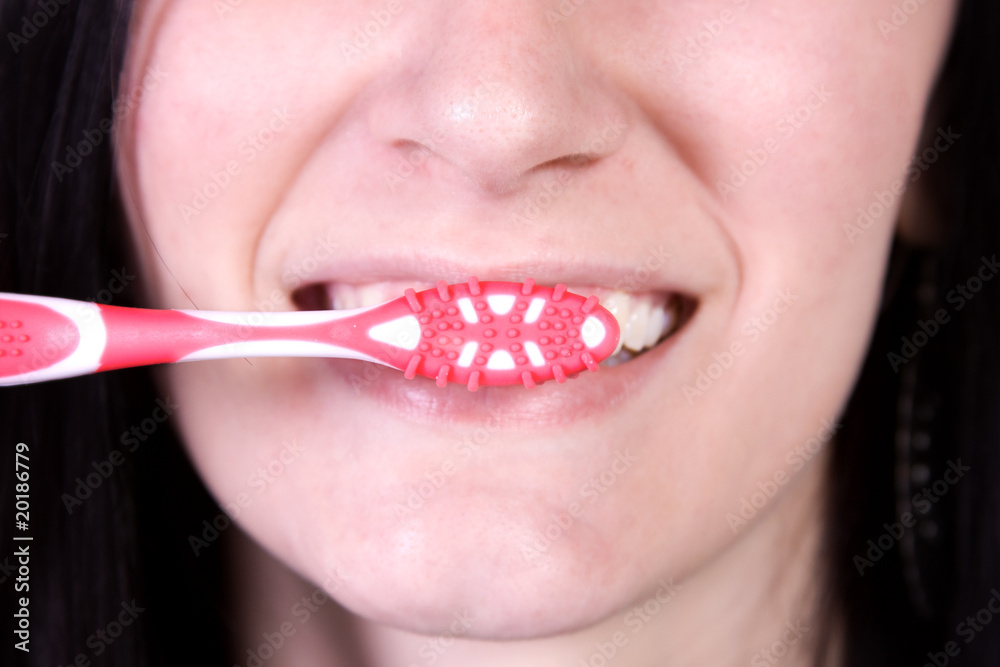 Fototapeta premium Close up of a beautiful woman brushing her teeth