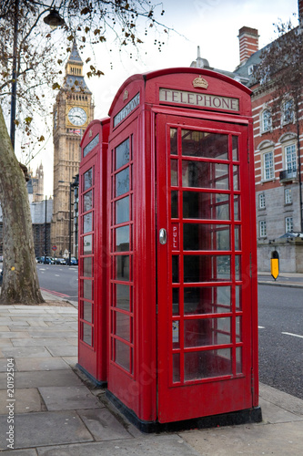 A pair of typical red phone booths in London with the Big Ben in