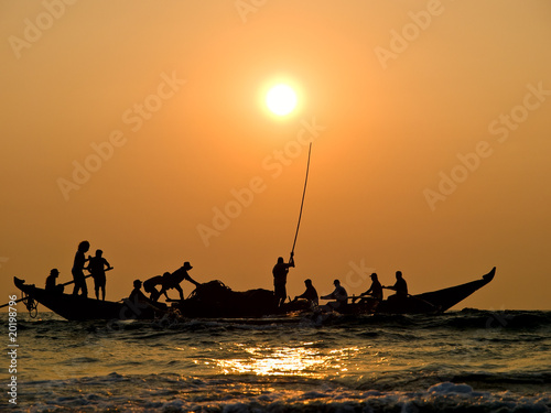 Fishers' boat in sunset