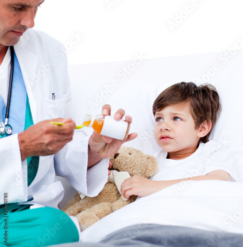 Adorable little boy taking cough medicine