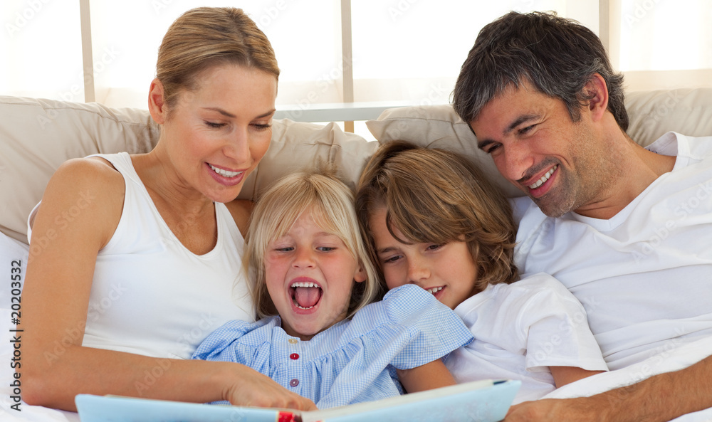 Jolly family reading a book on bed Jolly family reading a book on bed