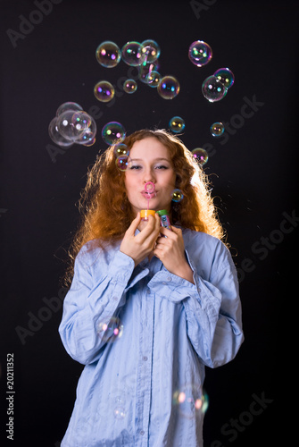 girl with red hair blow bubbles