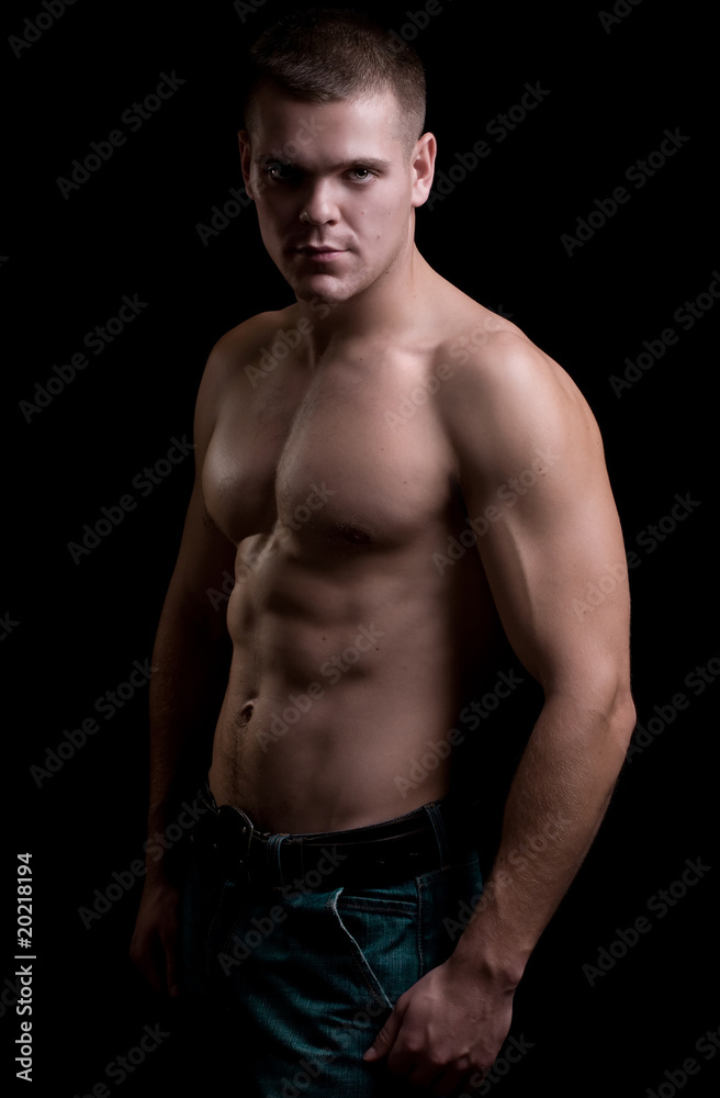 strong athletic man on black background