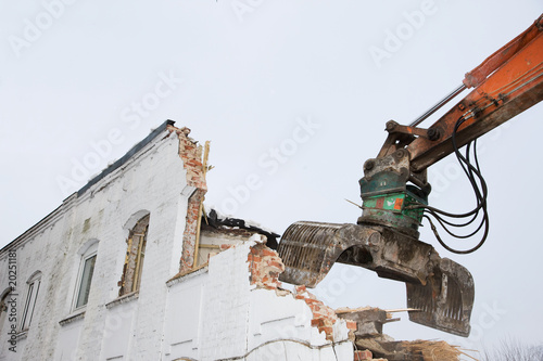 Abriss eines alten Gebäudes durch einen Bagger photo