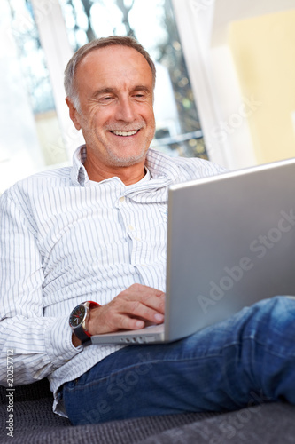 Mature man with laptop smiling photo