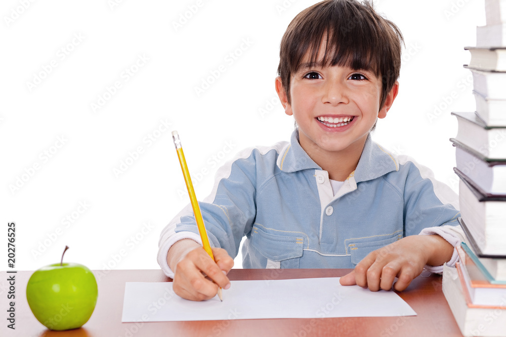 School boy doing his homework with an apple beside him School boy doing his homework with an apple beside him