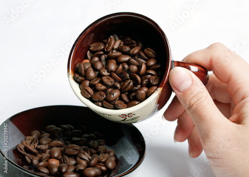 Wallpaper Mural Cup with coffee beans turned by a hand. Torontodigital.ca