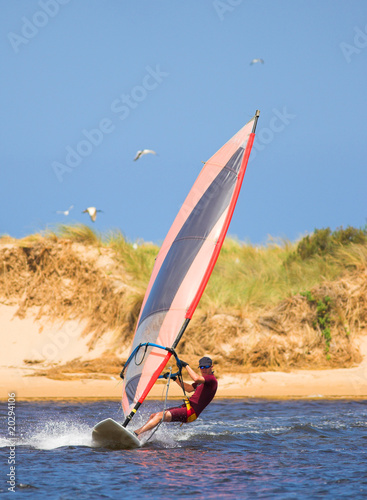 Fast moving windsurfer on the water photo