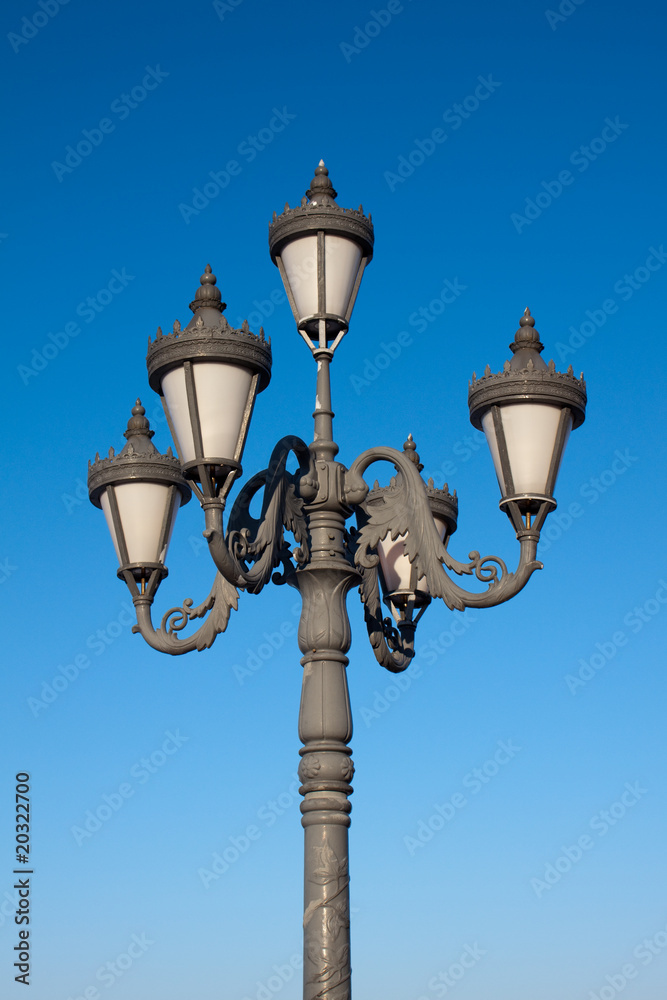 Old fashioned street lamp over blue sky