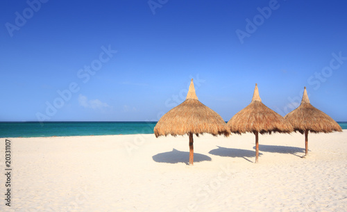 Grass umbrellas on a white sand beach