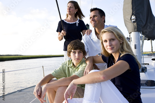 Family with teenage children sitting on boat at dock