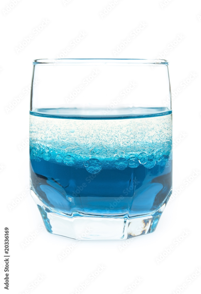 glass with blue liquid and bubbles of oil on a white background glass with blue liquid and bubbles of oil on a white background