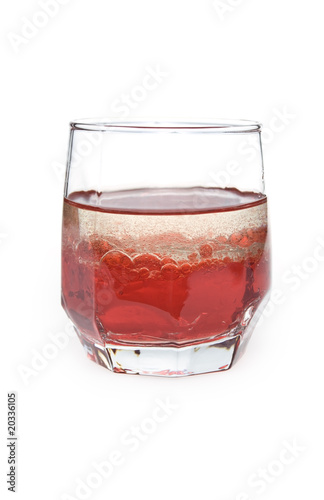 glass with red liquid and bubbles of oil