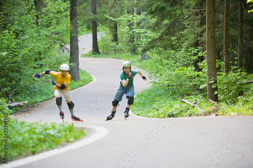 Bild auf Leinwand Two men rollerblading at park