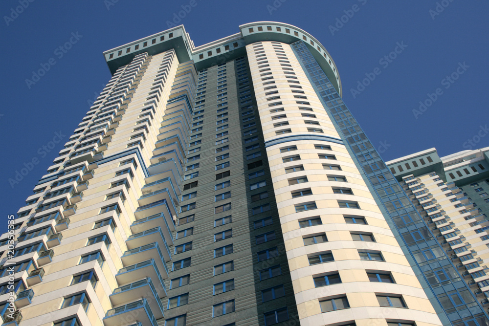 The bottom view on a modern building against the blue sky The bottom view on a modern building against the blue sky