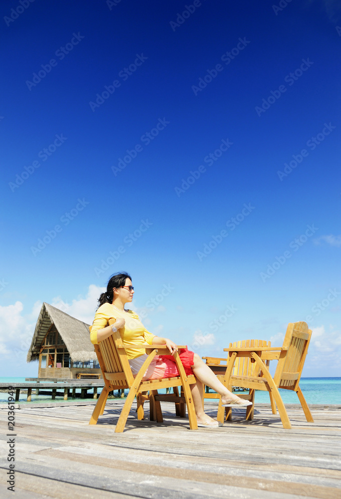 Fototapeta premium lady was sitting at chair at beach of Maldives