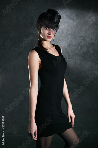 Portrait of the beautiful girl against a dark gray wall
