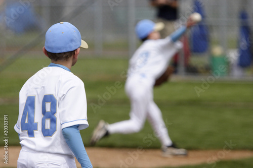 young third baseman watching the pitcher throwing the ball