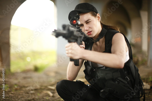 young and attractive woman holding an assault rifle © Peter Kim