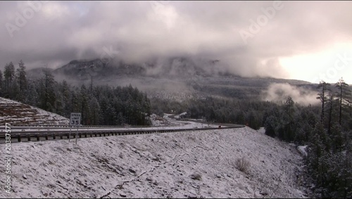 Mpountain snow storm with car passing by photo