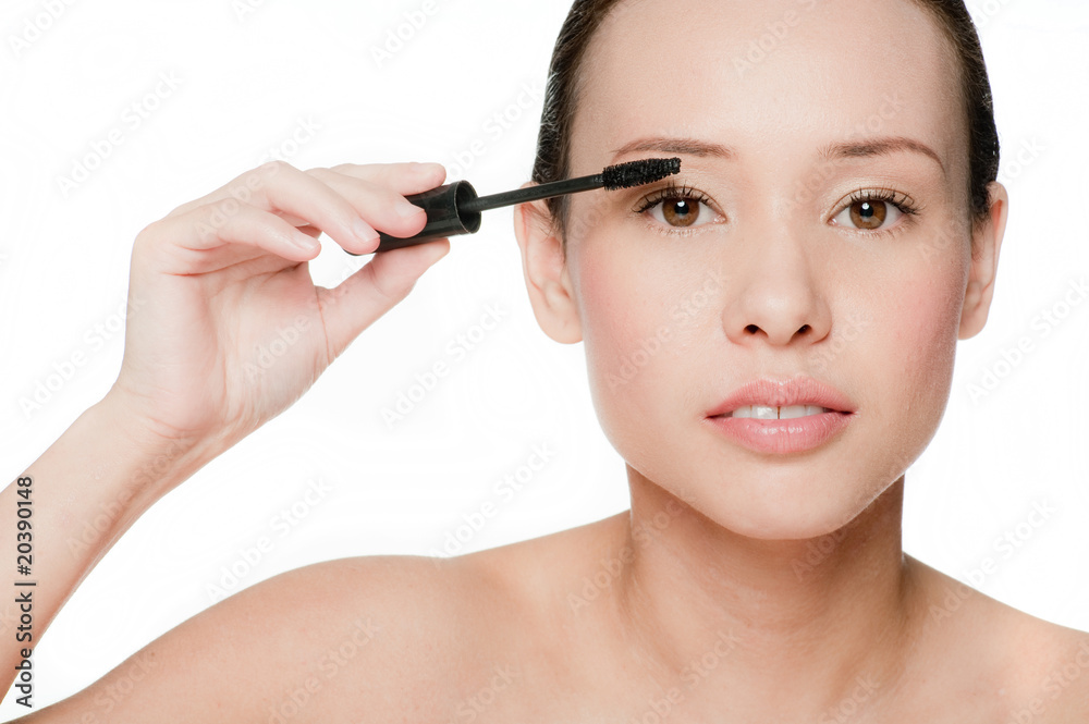 Young and attractive woman applying mascara Young and attractive woman applying mascara