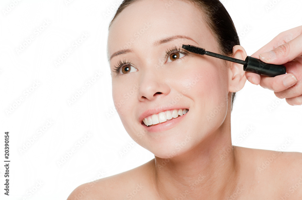 Young and attractive woman applying mascara Young and attractive woman applying mascara