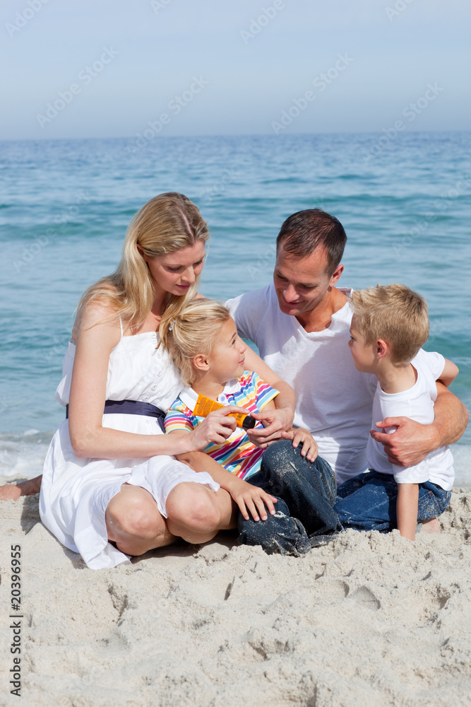 Caring mother with her family holding sunscreen Caring mother with her family holding sunscreen