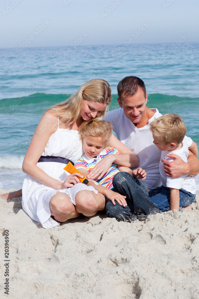 Smiling mother with her family holding sunscreen Smiling mother with her family holding sunscreen