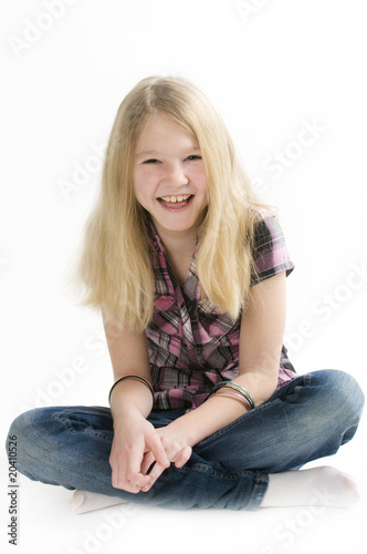 Lachendes junges Mädchen im Schneidersitz