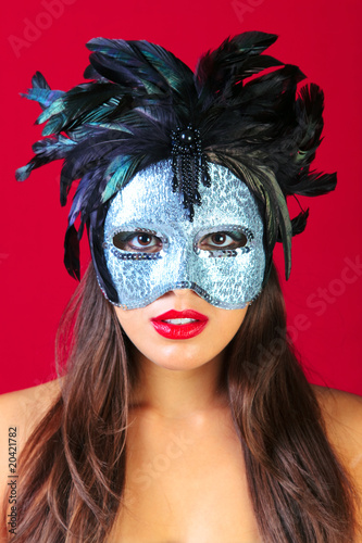Woman wearing a masquerade mask red background